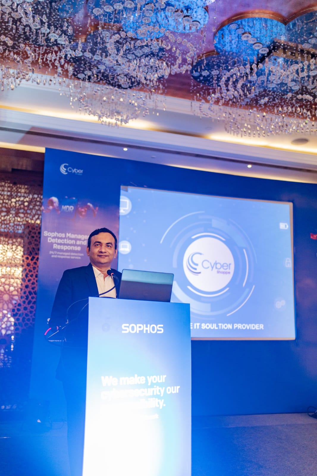 A Cyber Shoppe director presenting from the Sophos podium at the company's Managed Detection and Response event in 2024.
